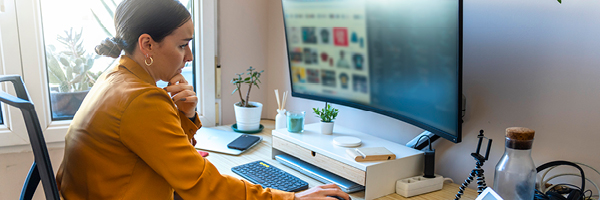 woman in her office working on computer and tablet